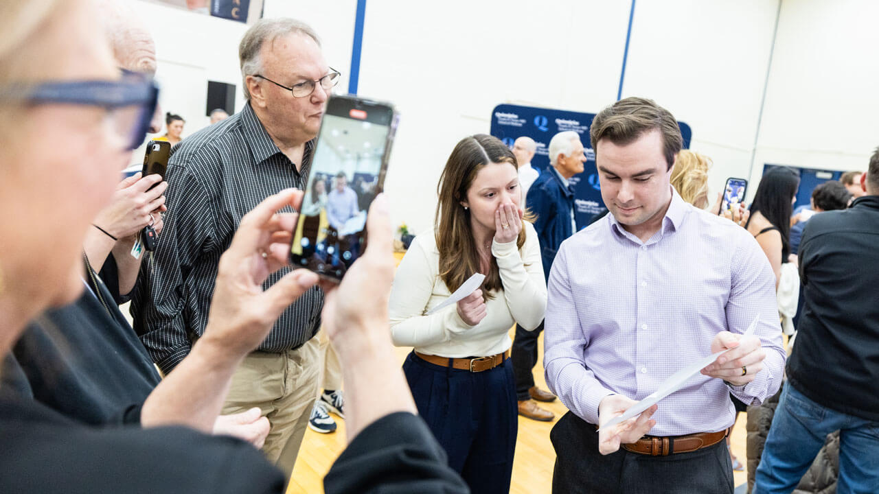 School of Medicine student shows his placement to a shocked loved one