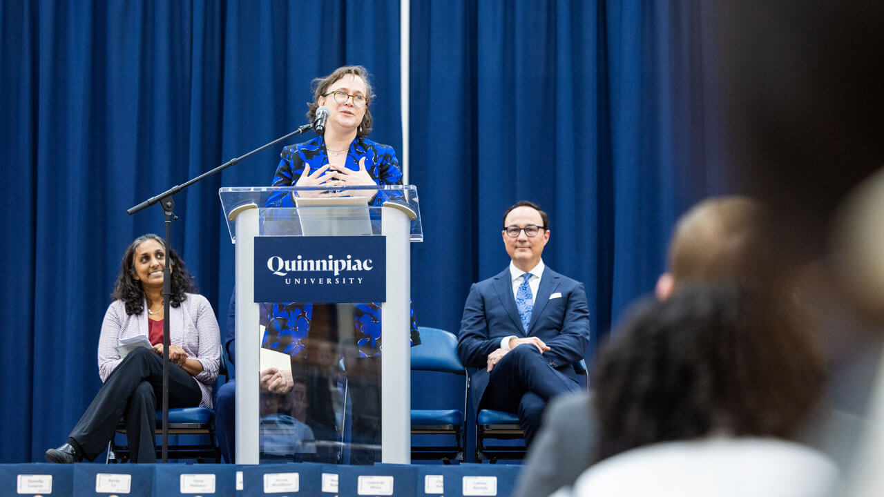 School of Medicine administrator speaks at the podium to a crowd