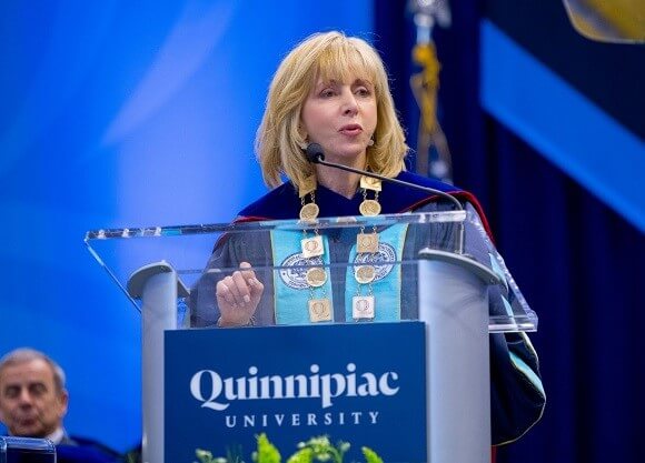 President Olian speaks in front of a banner stating. The University of Your Future