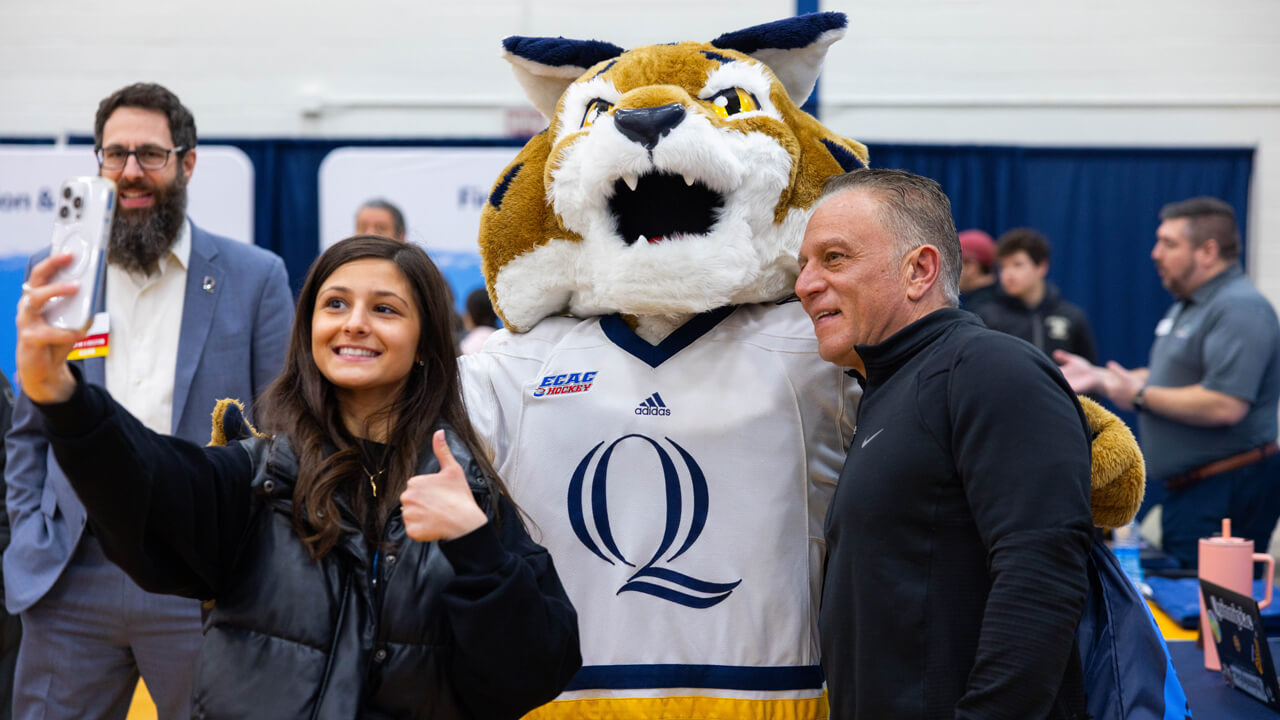 Boomer poses for a photo with two people