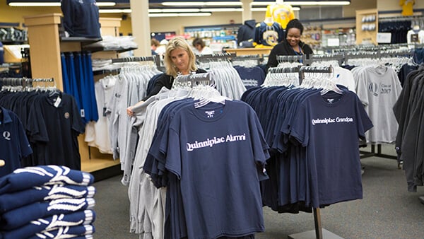 Individual selecting merch to purchase at the Quinnipiac Bookstore