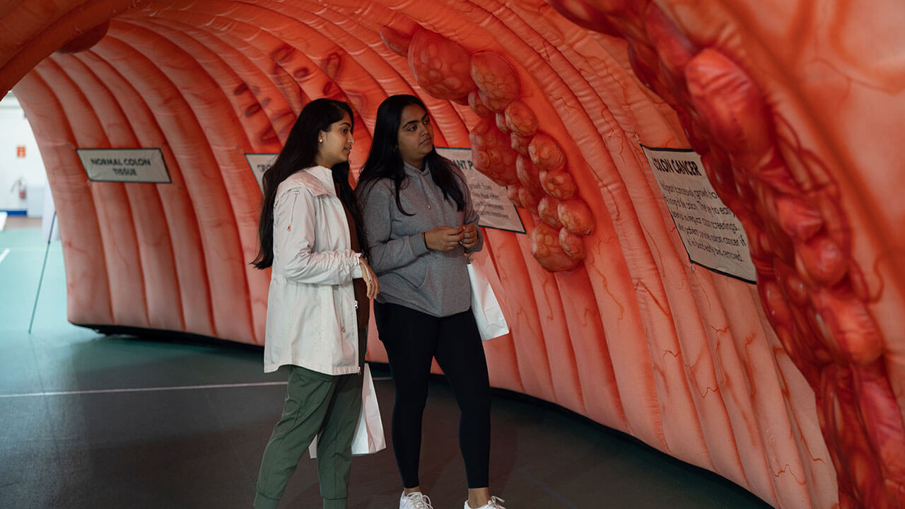 Students walking through an inflatable colon