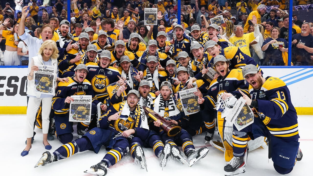 Judy Olian poses with the National Championship men's ice hockey team