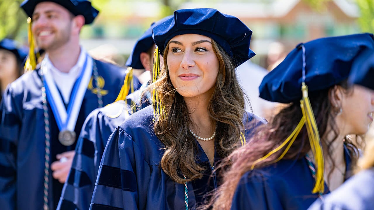 A graduate smiling into the distance