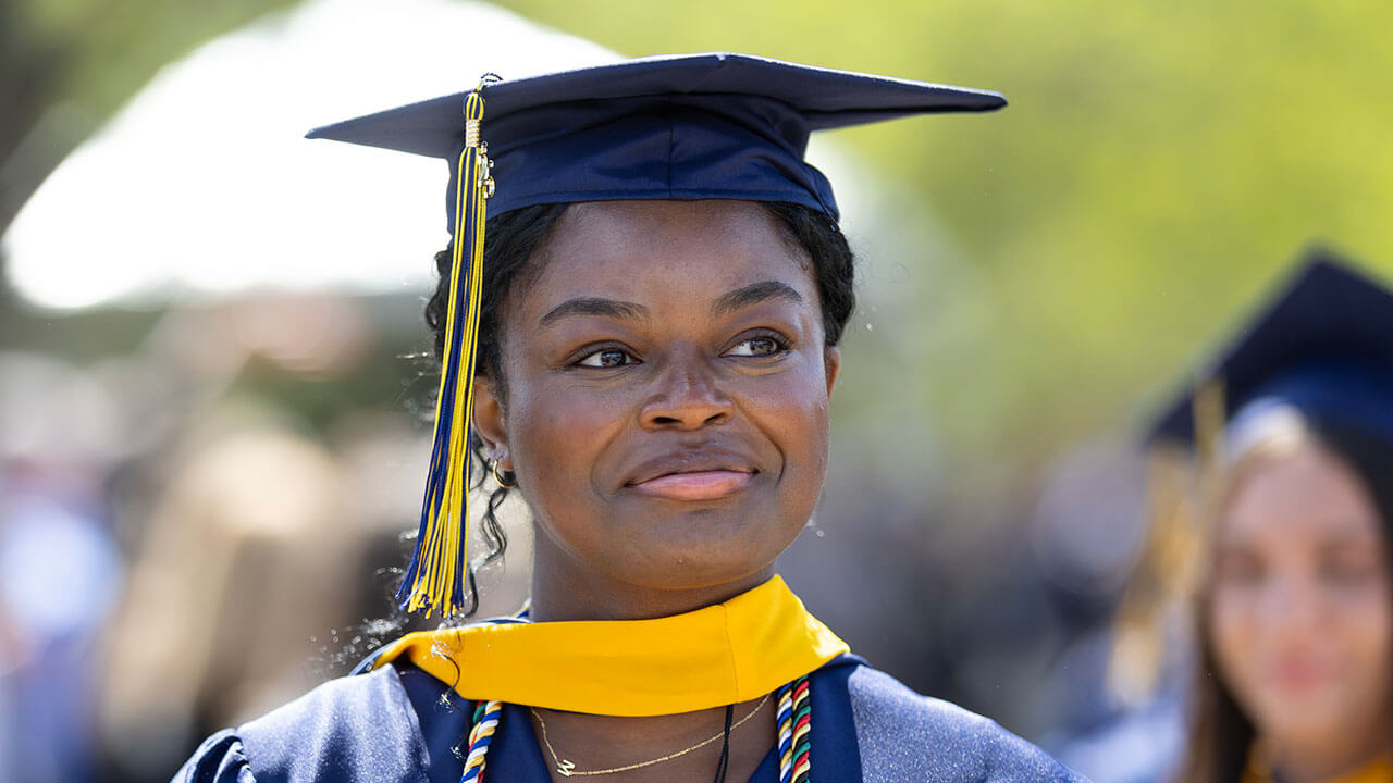 A graduate smiling into the distance