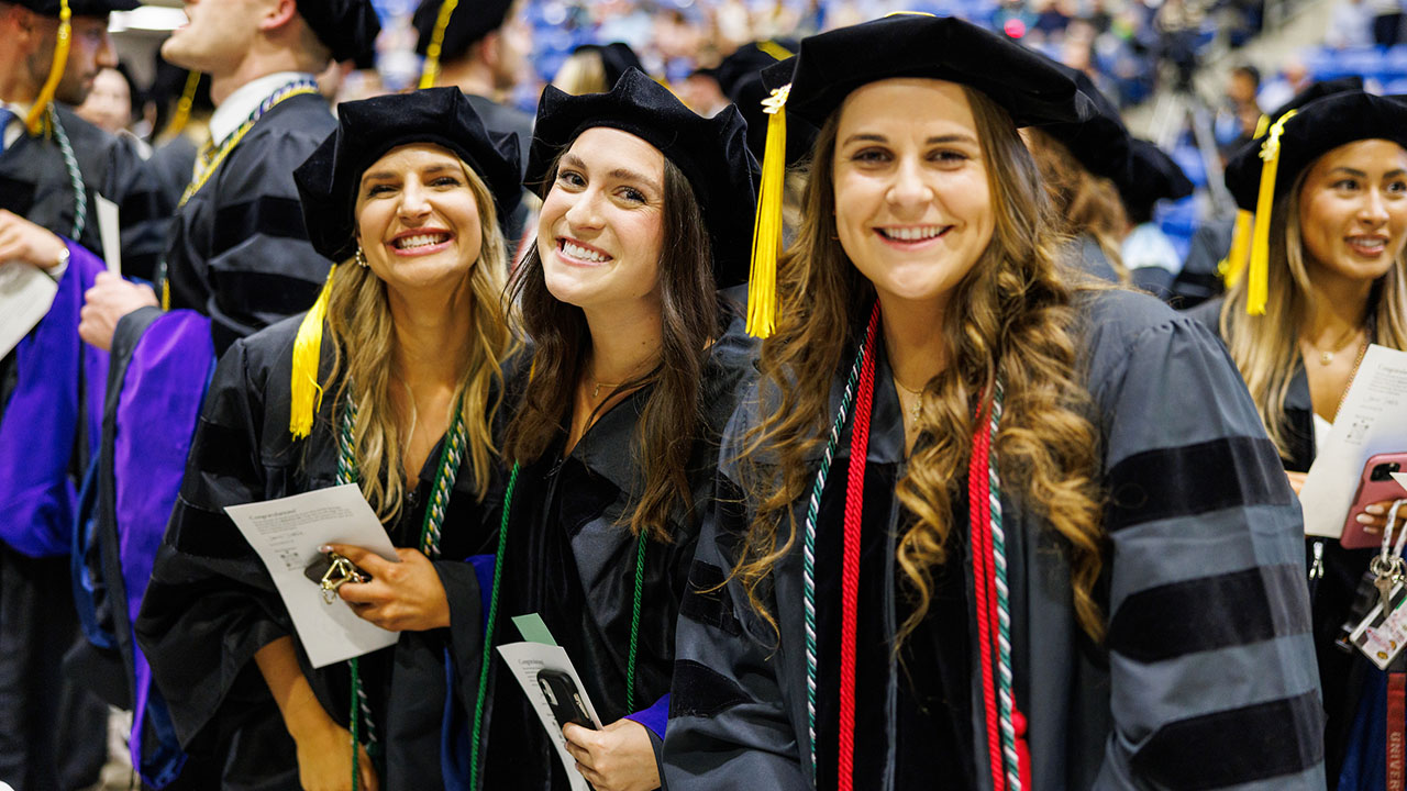 Graduates smile in their seats during commencement