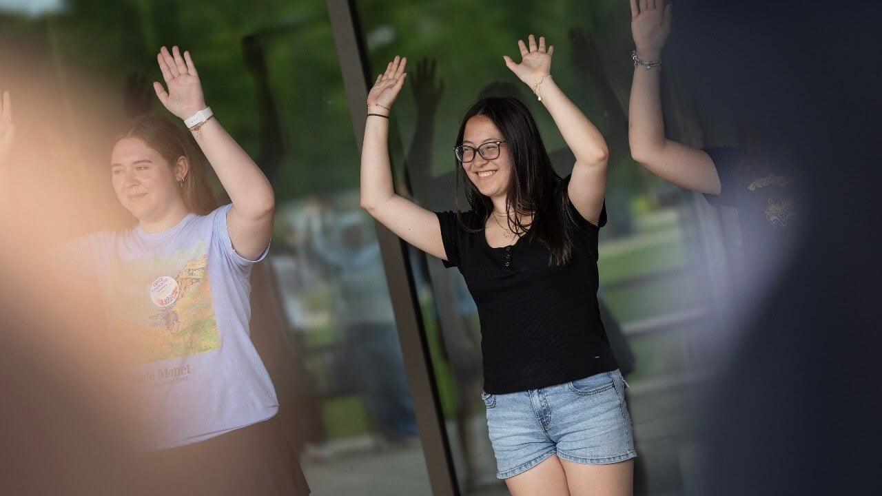 Students with their arms raised