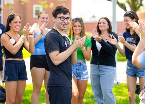 Individuals standing and smiling during Orientation