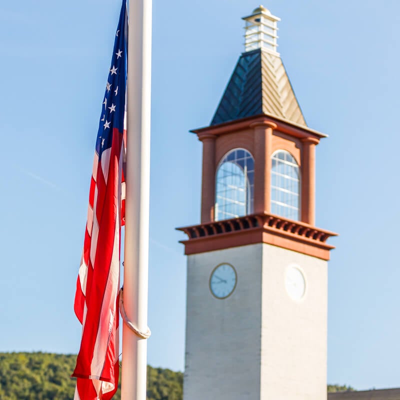 The American flag hangs in front of the Quinnipiac clocktower