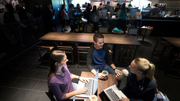 Friends sitting at Starbucks with laptops open