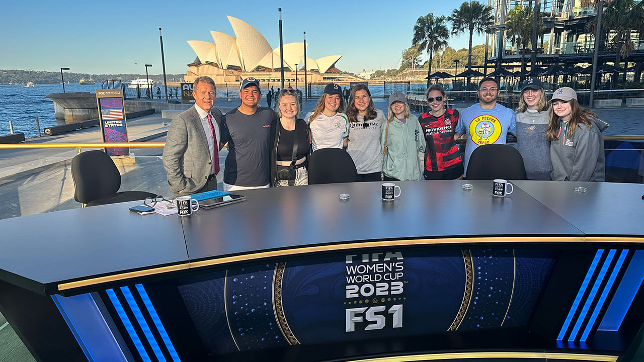 Students take a photo with Rob Stone, a sports commentator for Fox Sports
