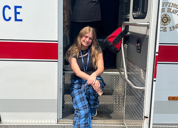 Skyla Luzzi Porco sitting on the side of an ambulance