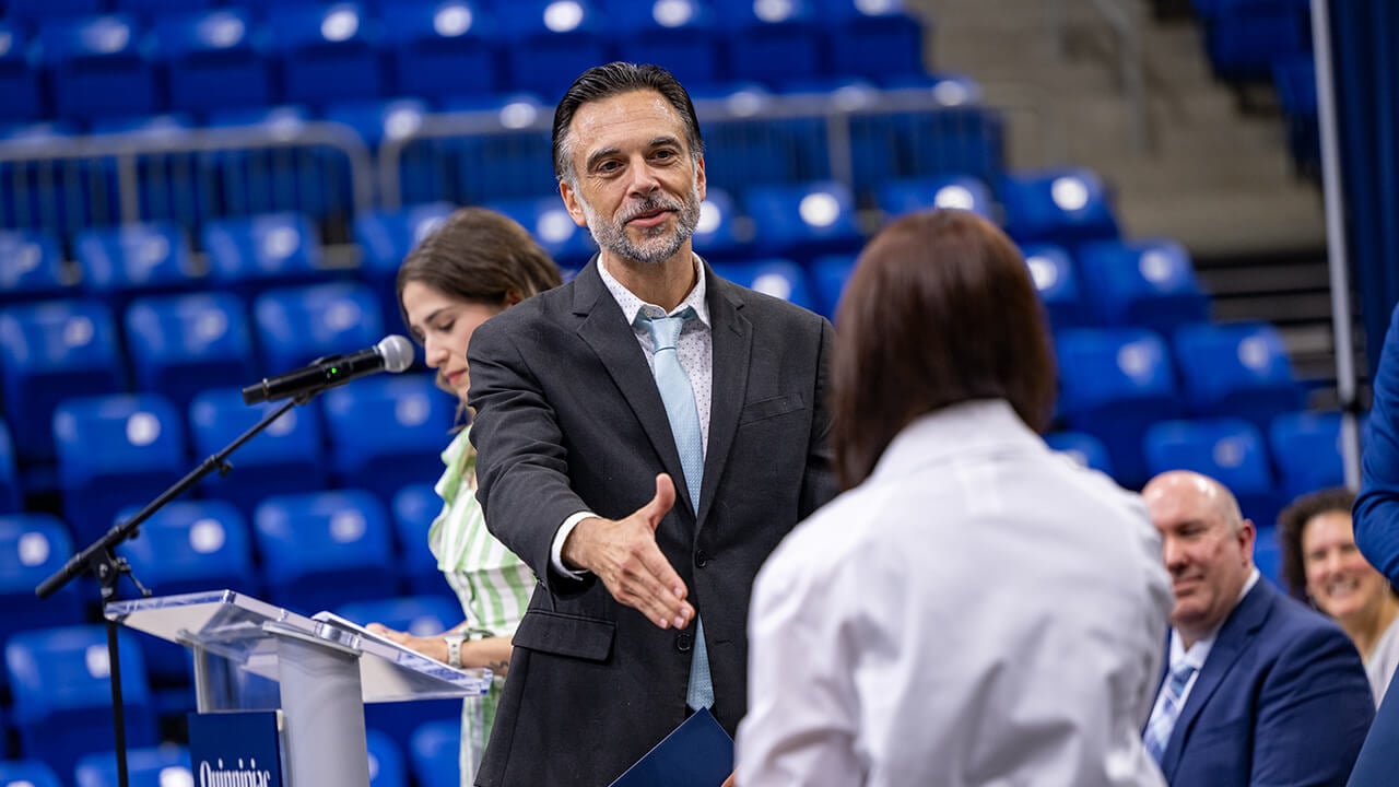 Dean shaking student's hand