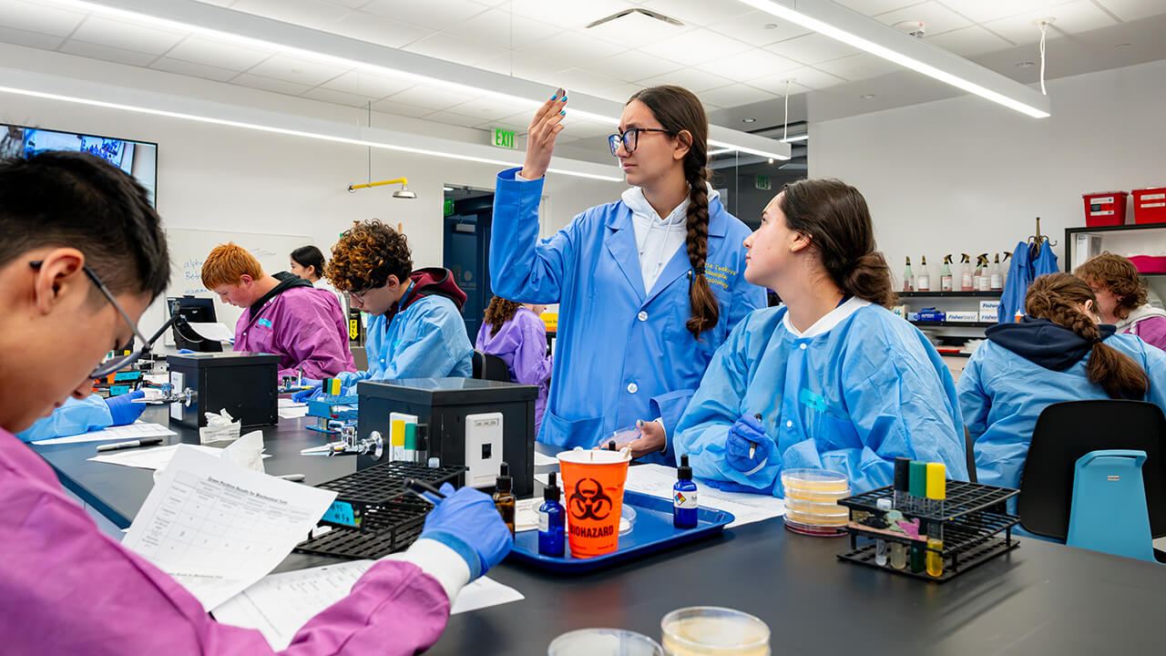 Student leader and high schooler looking at sample