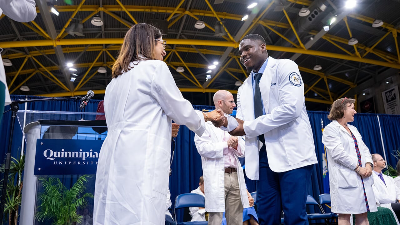 Student and dean shaking hands