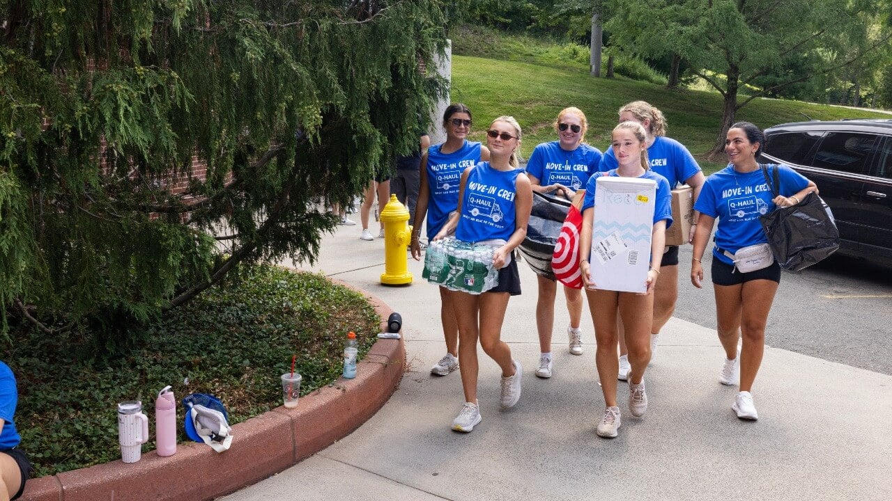 Three move-in members carry student stuff