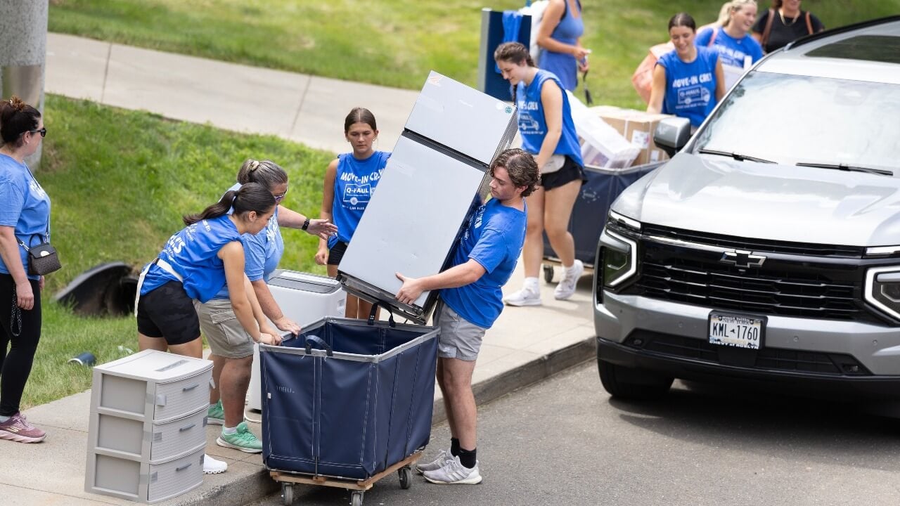 Move-in crew puts fridge into cart