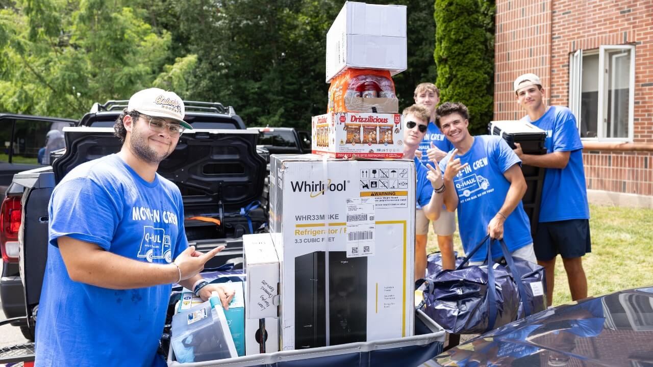 Students smile while helping with move-in