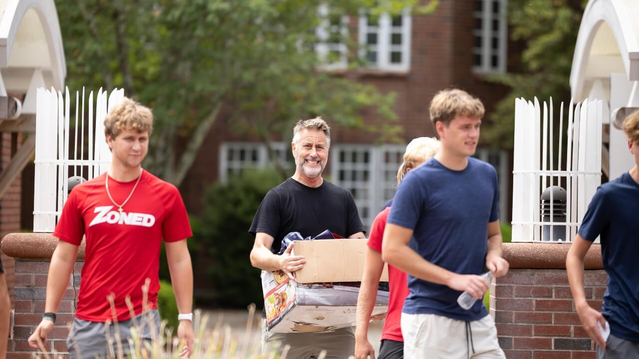 New student and their parents carry boxes