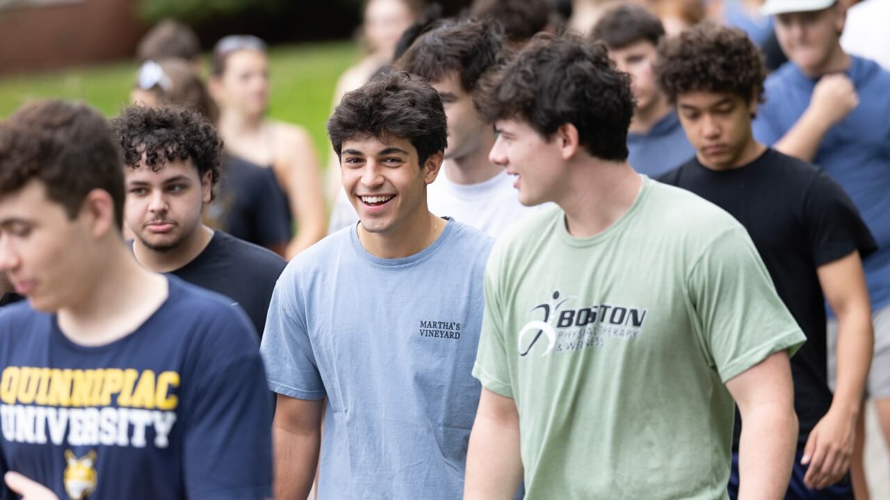 Class of 2030 students laugh together while walking on campus