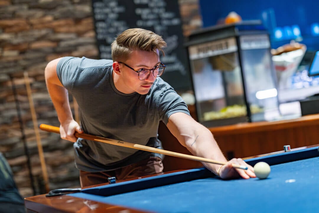 A Quinnipiac student plays pool while dining at On the Rocks Pub & Grill.