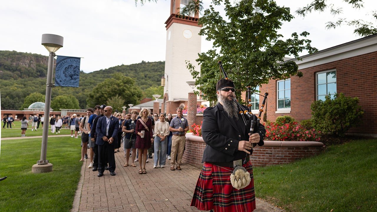Bagpiper leading procession away from library