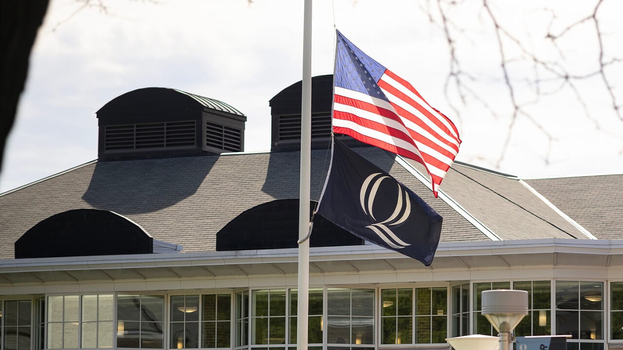 The American and Quinnipiac flag at half mast