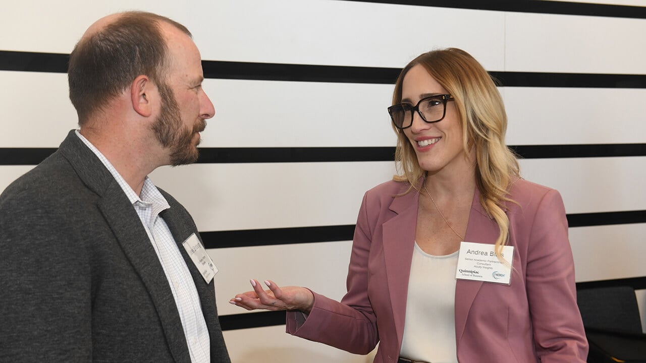 Two individuals smile at each other while having a conversation