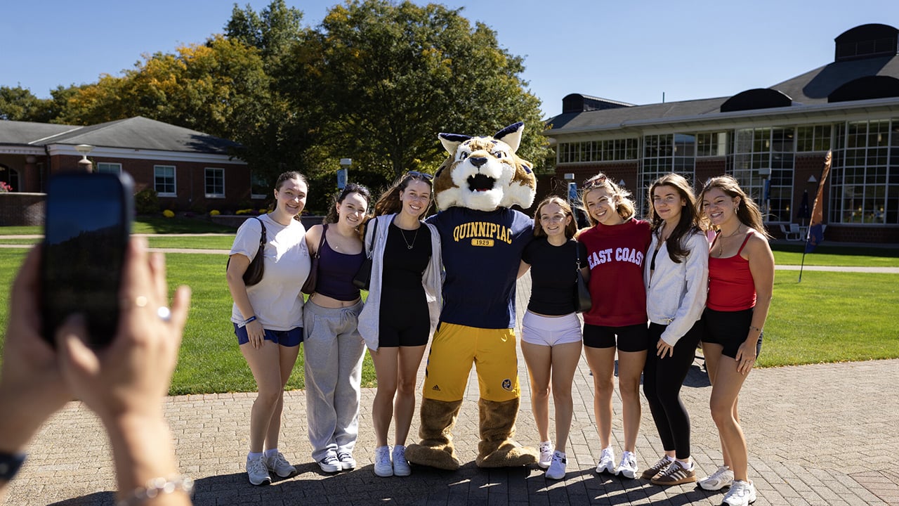 A group of people taking a photo with Boomer.