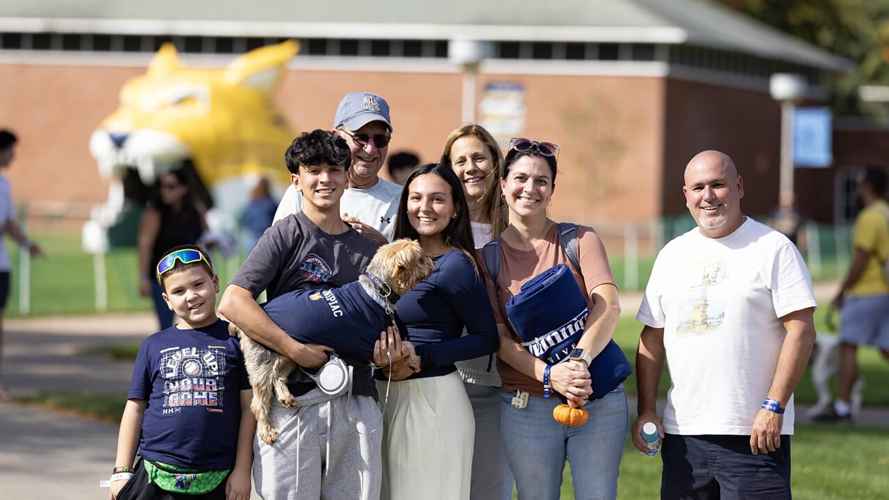A family posing for a picture with a dog.
