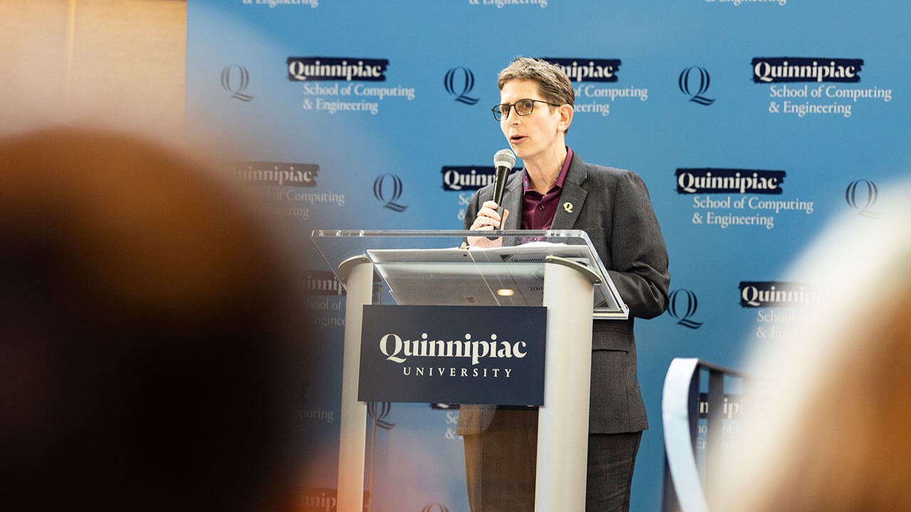 Provost Debra J. Liebowitz stands behind Quinnipiac University podium.