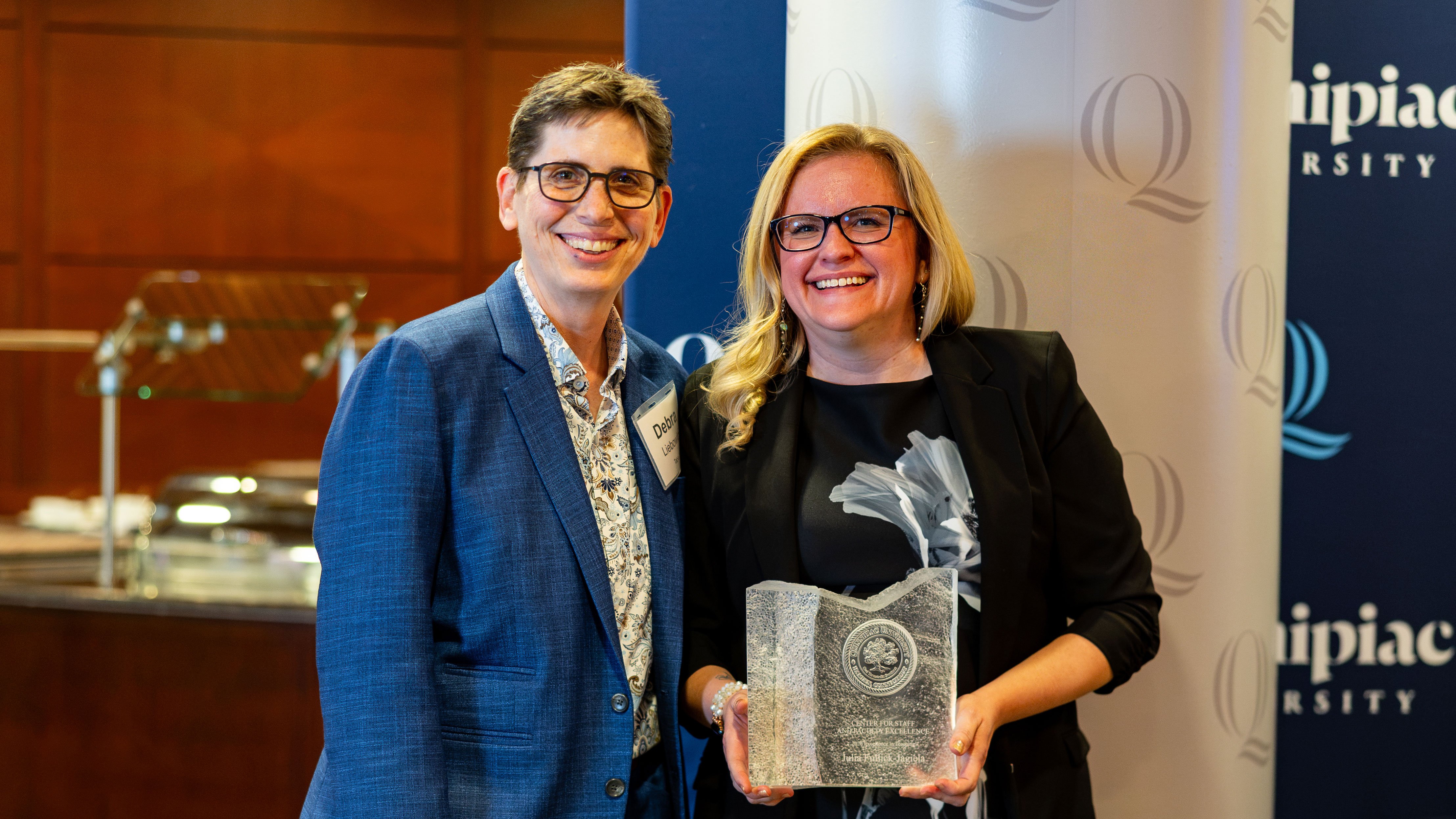 Julia Fullick-Jagiela receives her award and poses with Provost Debra Liebowitz.