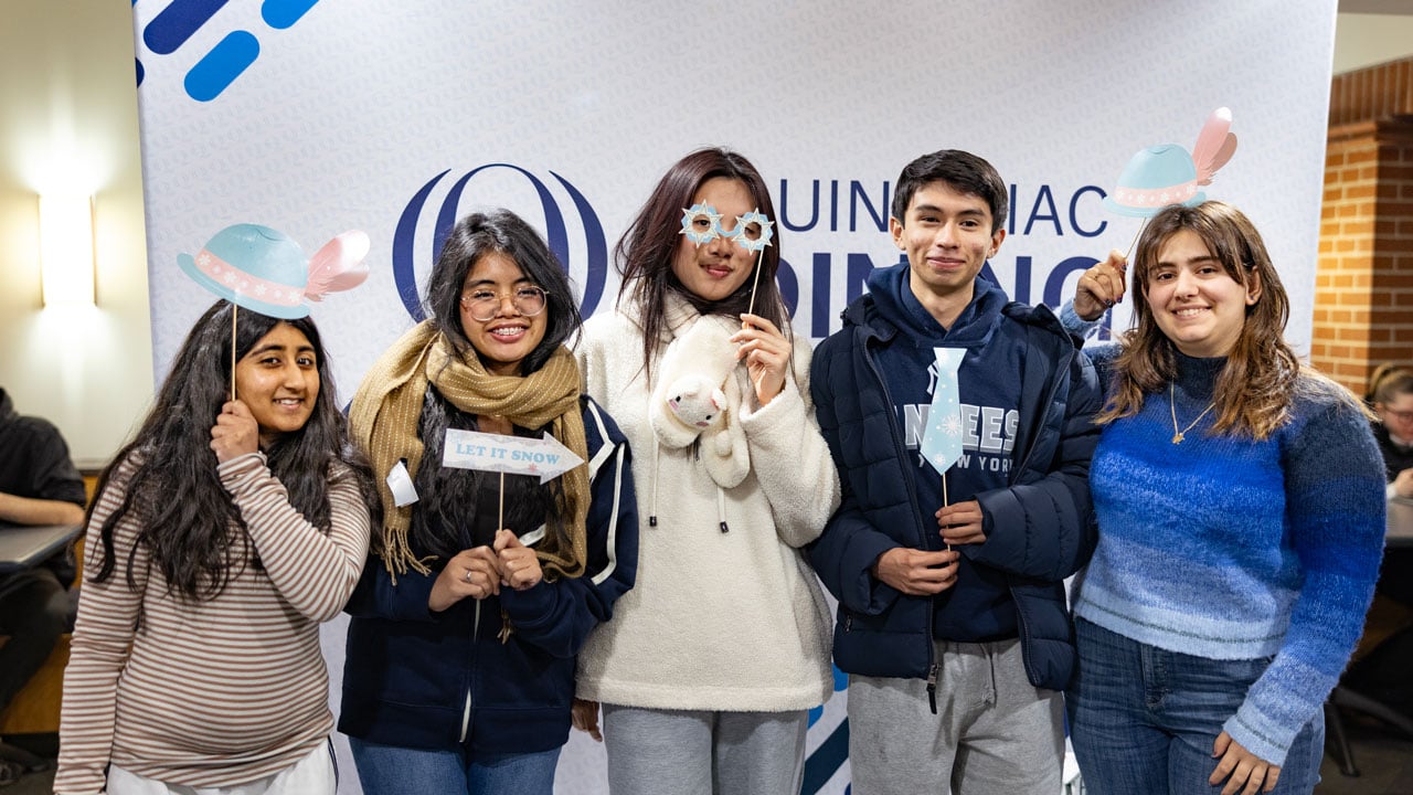 Students gather for a picture in front of the Quinnipiac Holiday Photo Booth